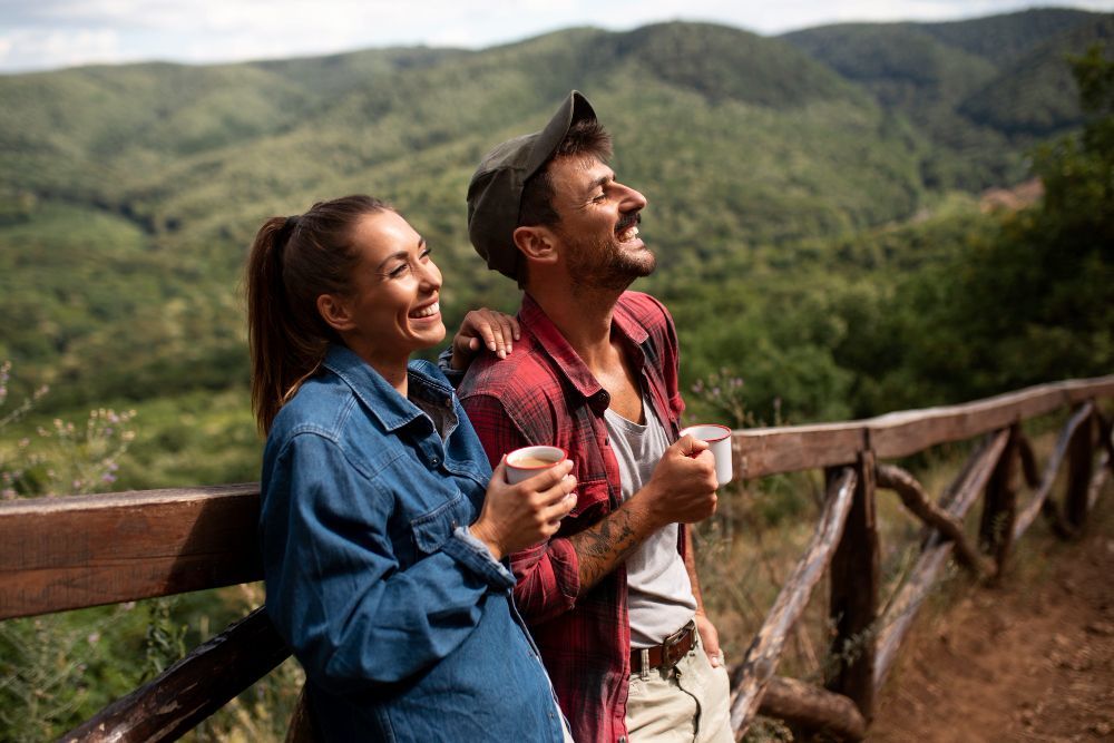 A man and a woman are standing next to each other on a wooden fence.