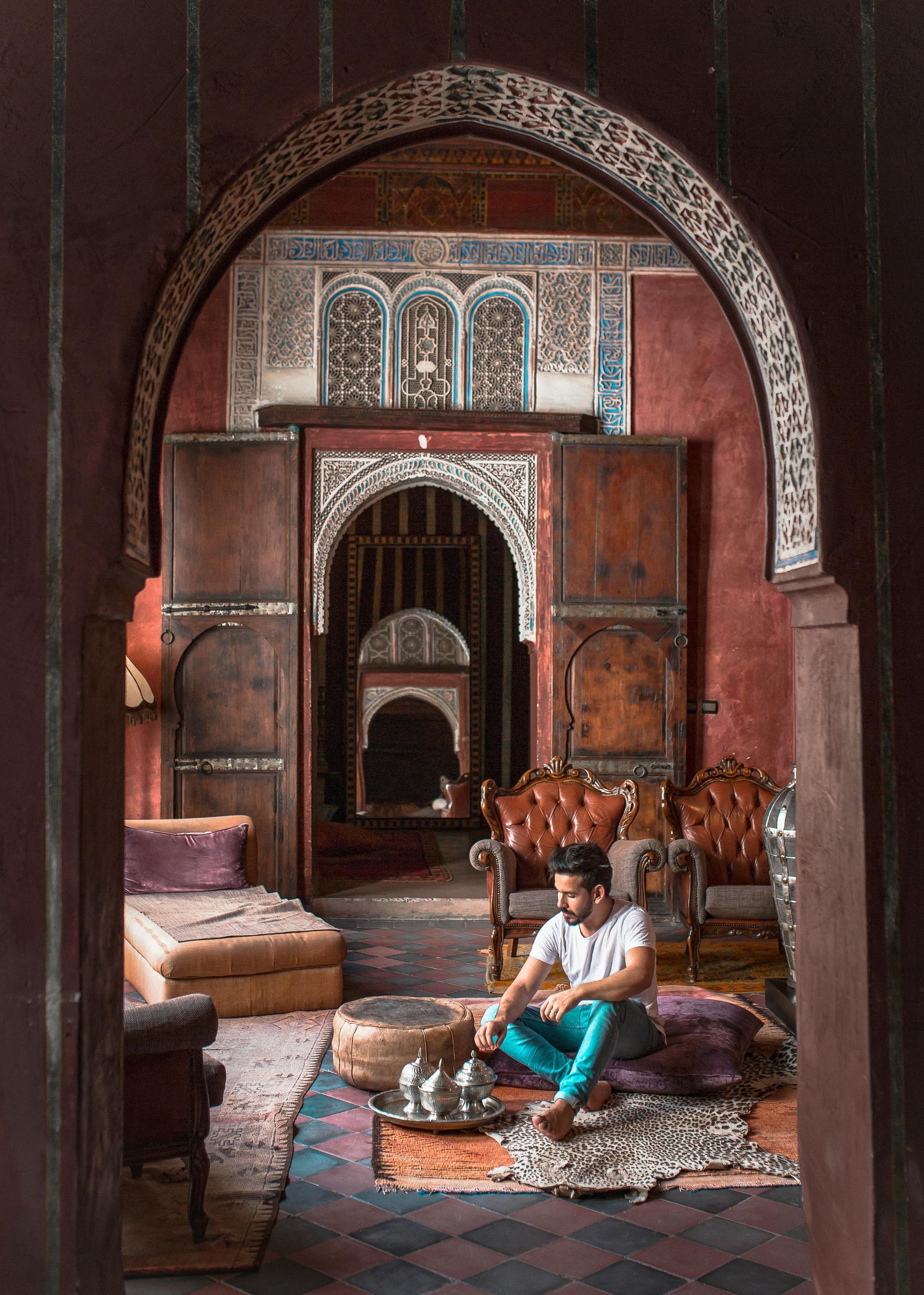 A man is sitting on a rug in a living room.