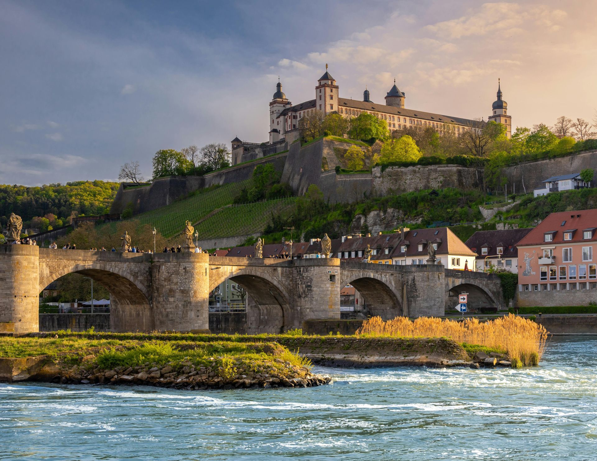 A bridge over a river with a castle in the background.