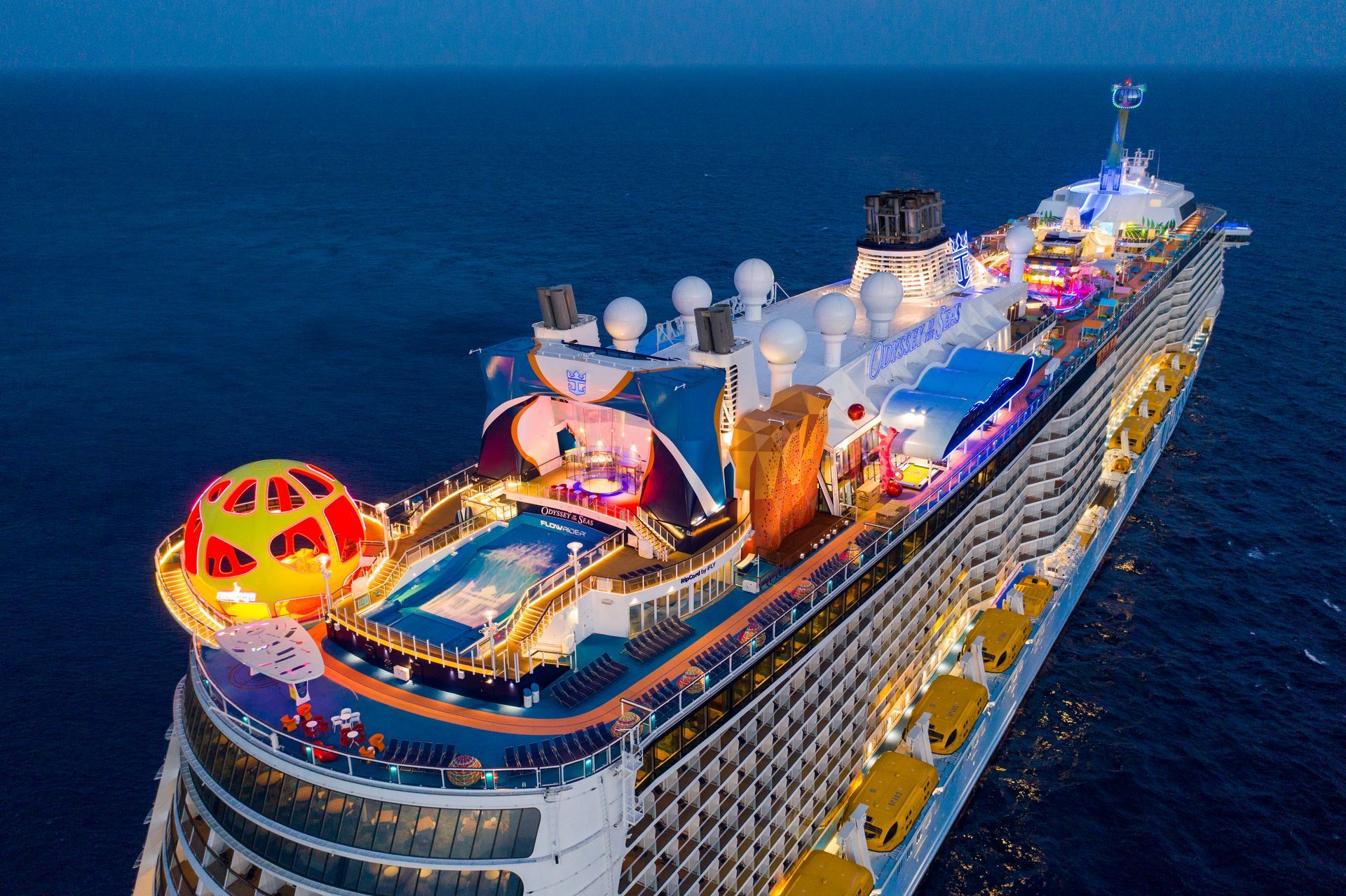 A large cruise ship is floating in the ocean at night.