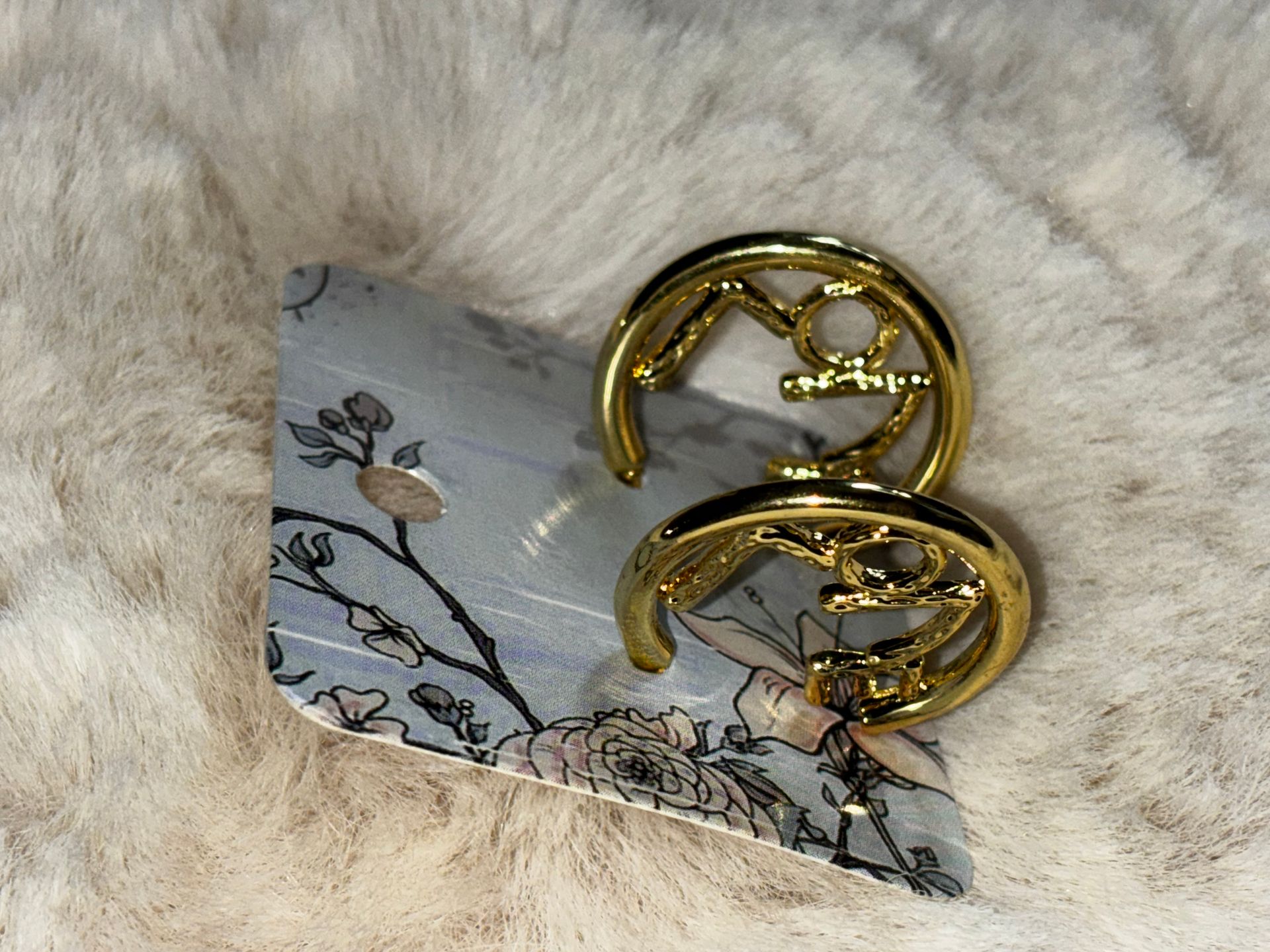 Goude oorbel met een figuurtje erin