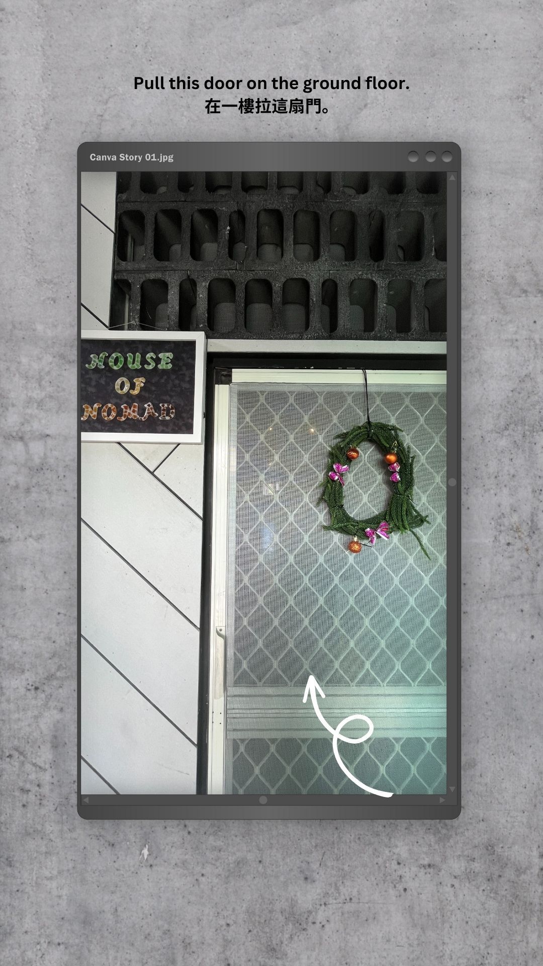 A christmas wreath is hanging from a window in a building.