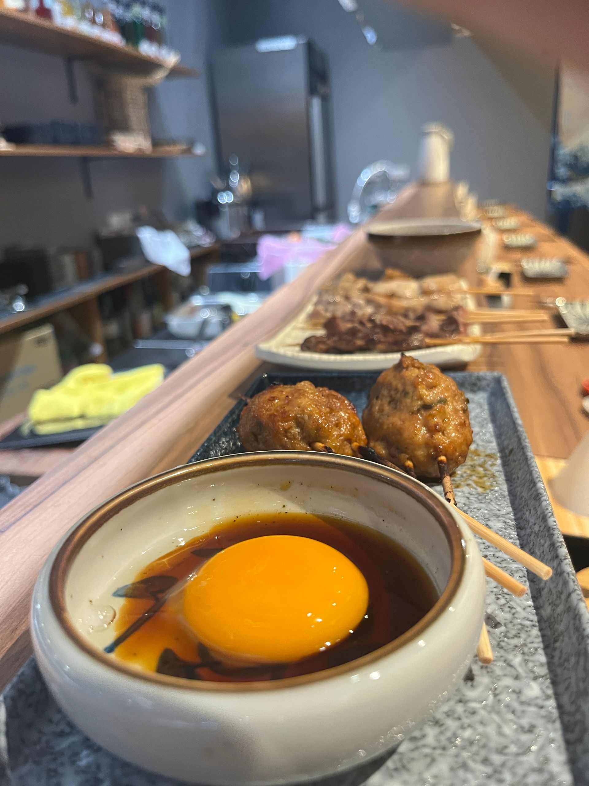 a bowl of sauce with an egg in it on a table .