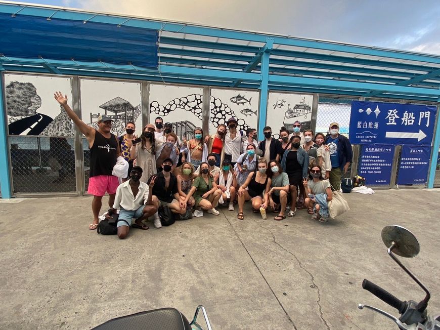 A group of people are posing for a picture in front of a building.