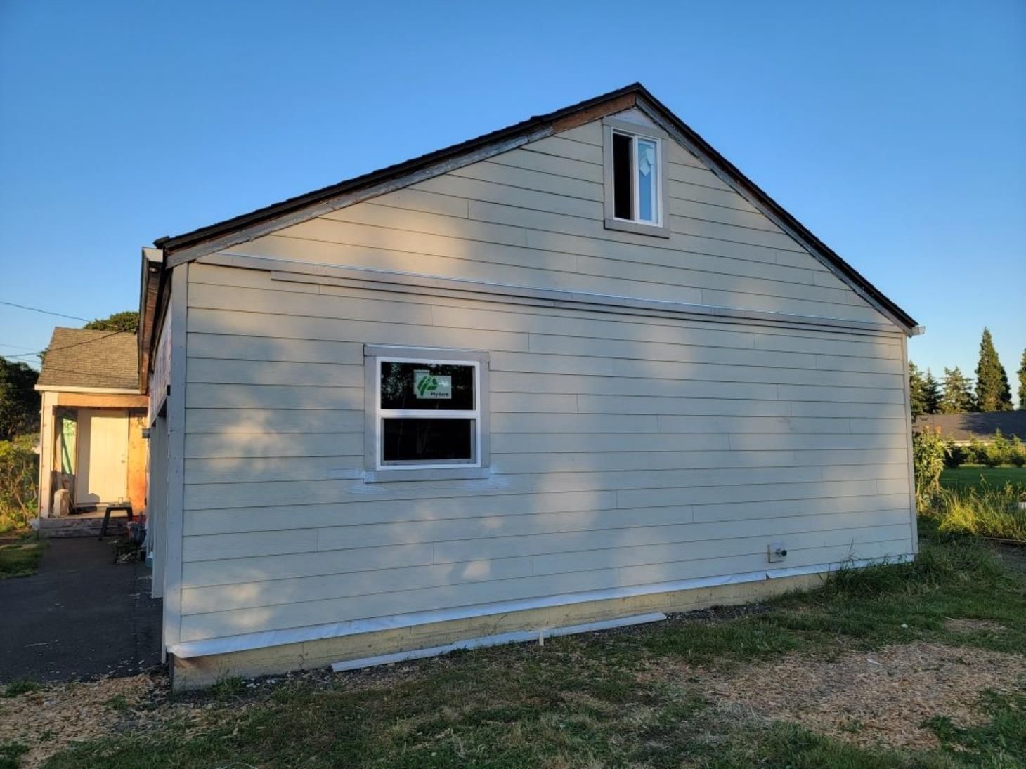 A man is using a drill to drill a hole in a wooden wall.