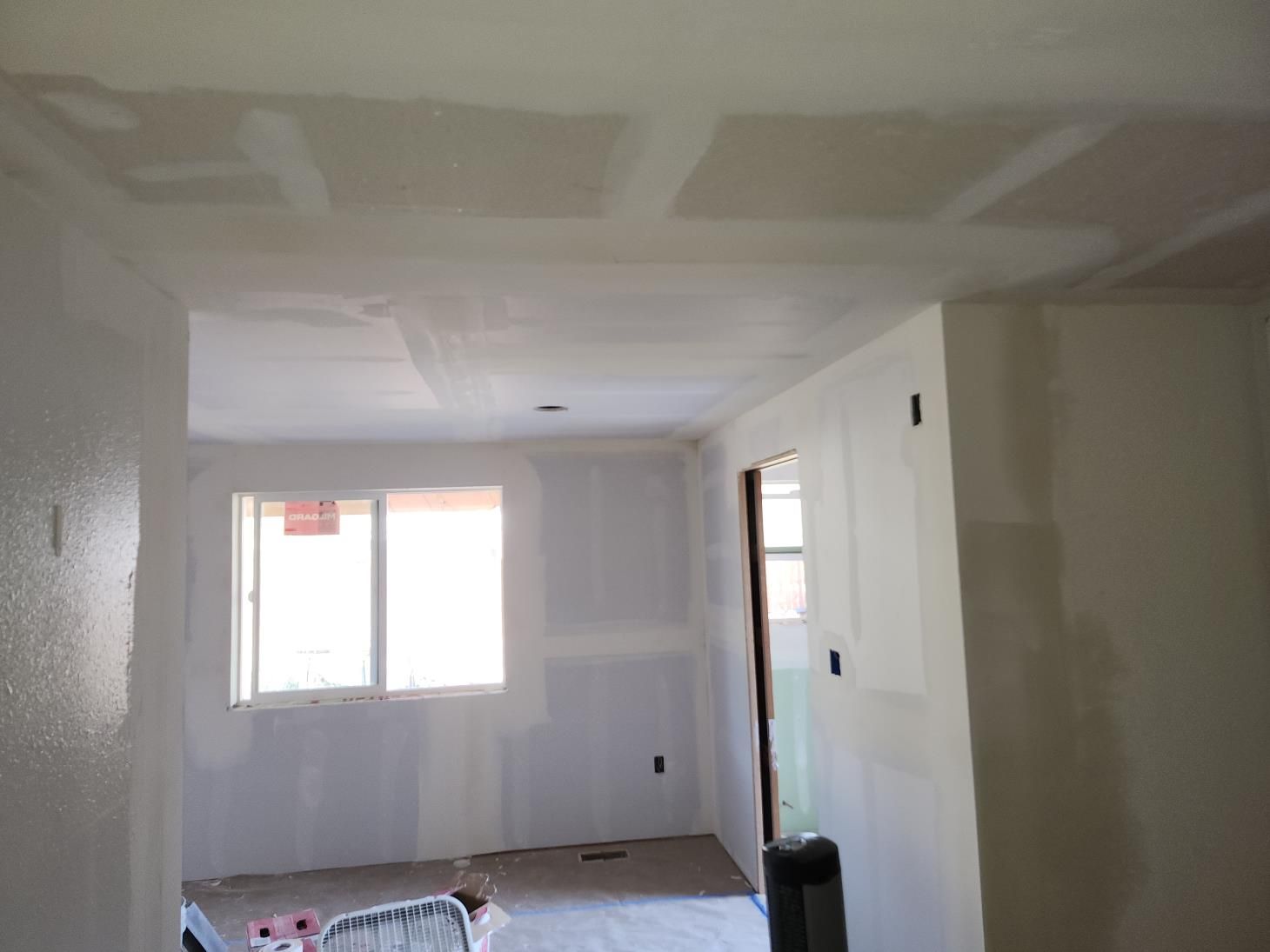 an attic under construction with wooden beams and a window .