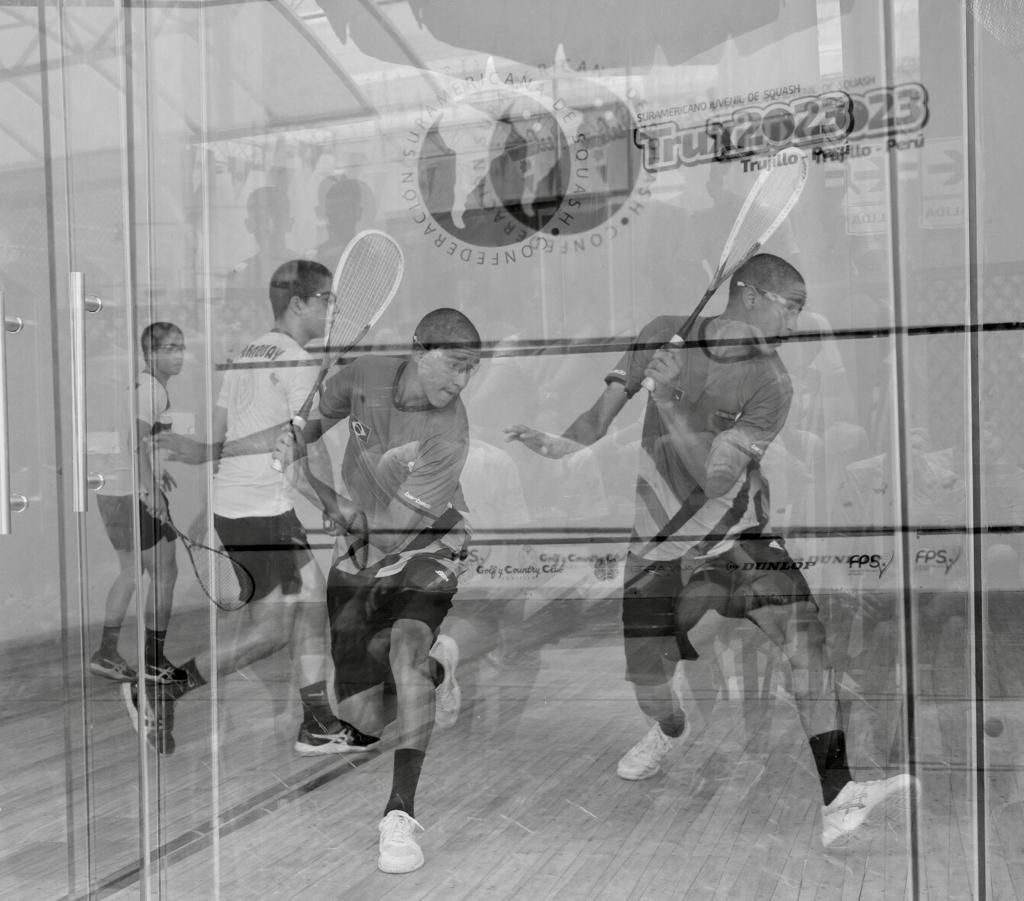 Um grupo de homens está jogando squash em uma quadra.