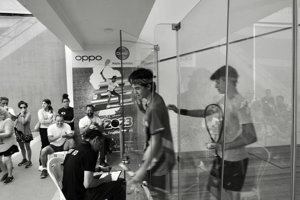 Uma foto em preto e branco de um grupo de pessoas jogando tênis