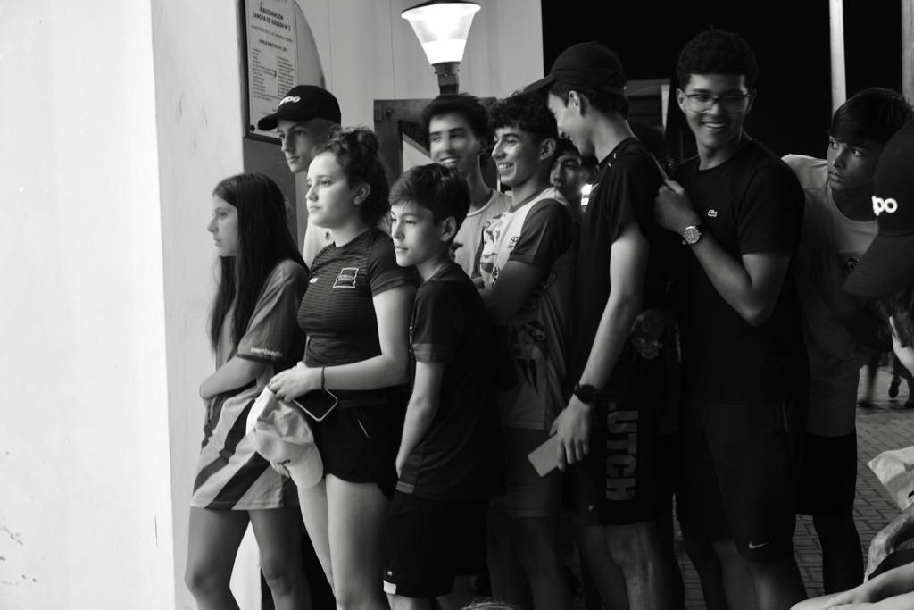 uma foto em preto e branco de um grupo de pessoas em uma fila.