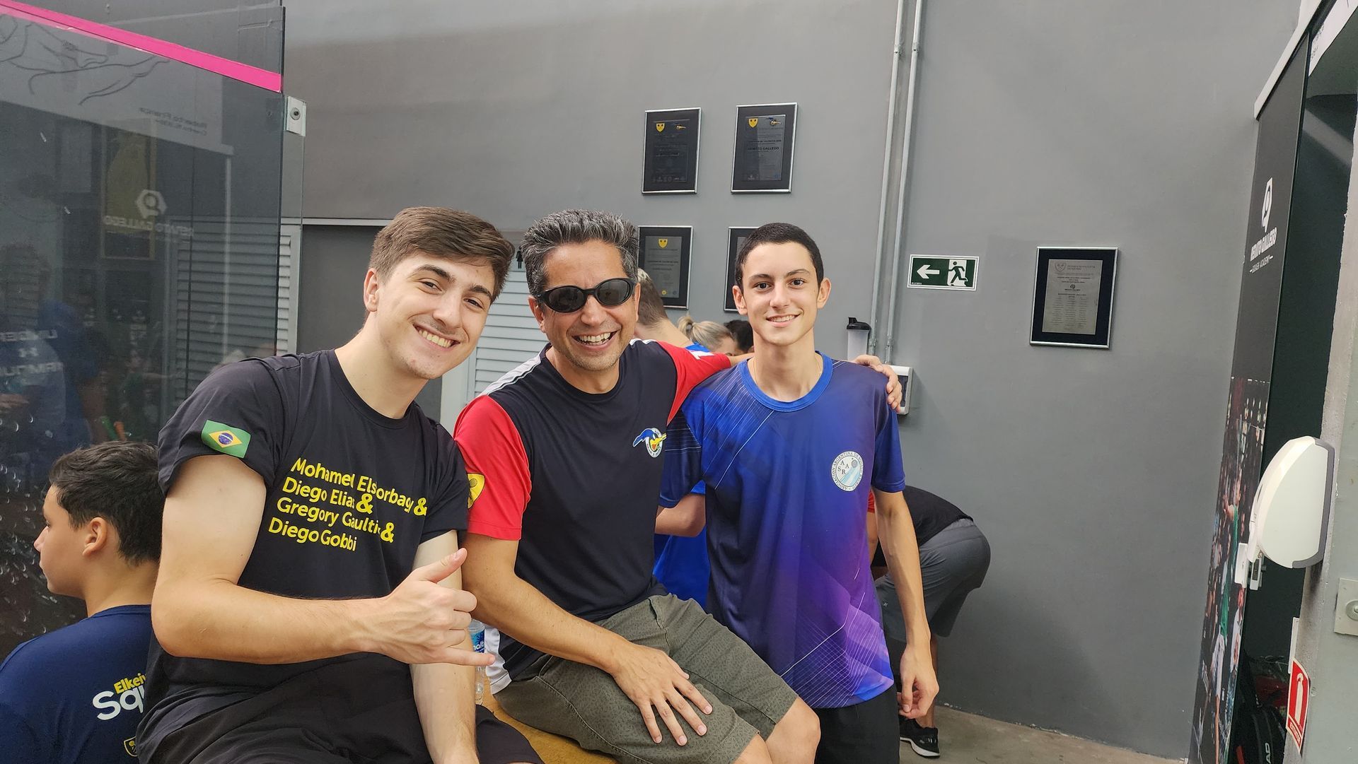 Um grupo de jovens está posando para uma foto em uma sala.