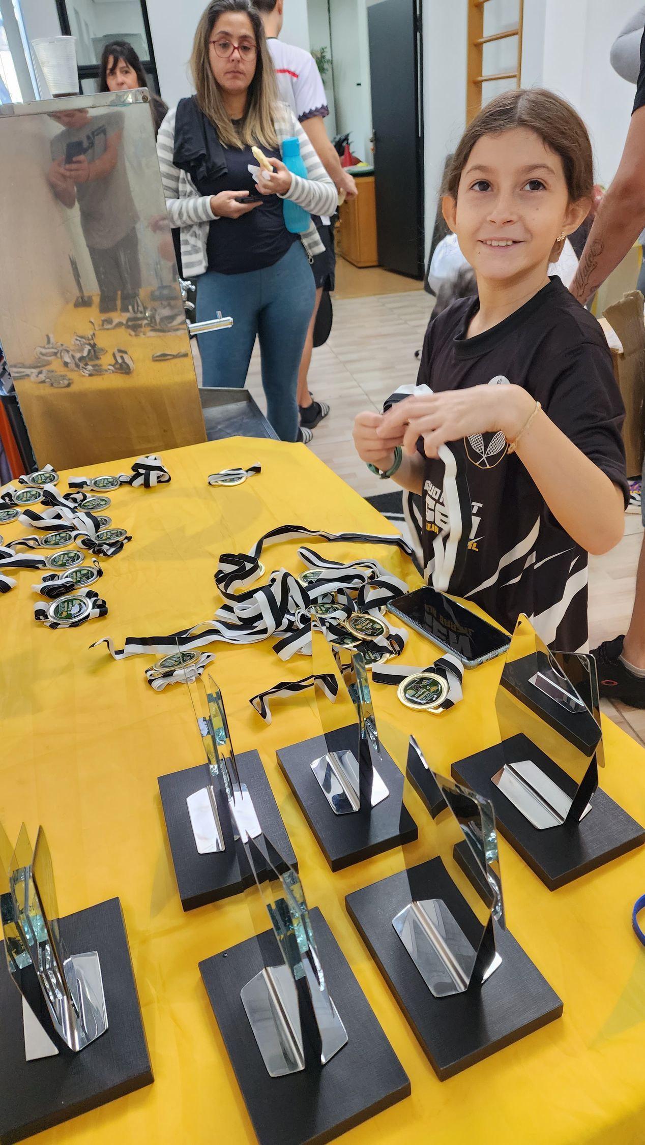 Um menino está sentado em uma mesa com um monte de brinquedos em cima dela.