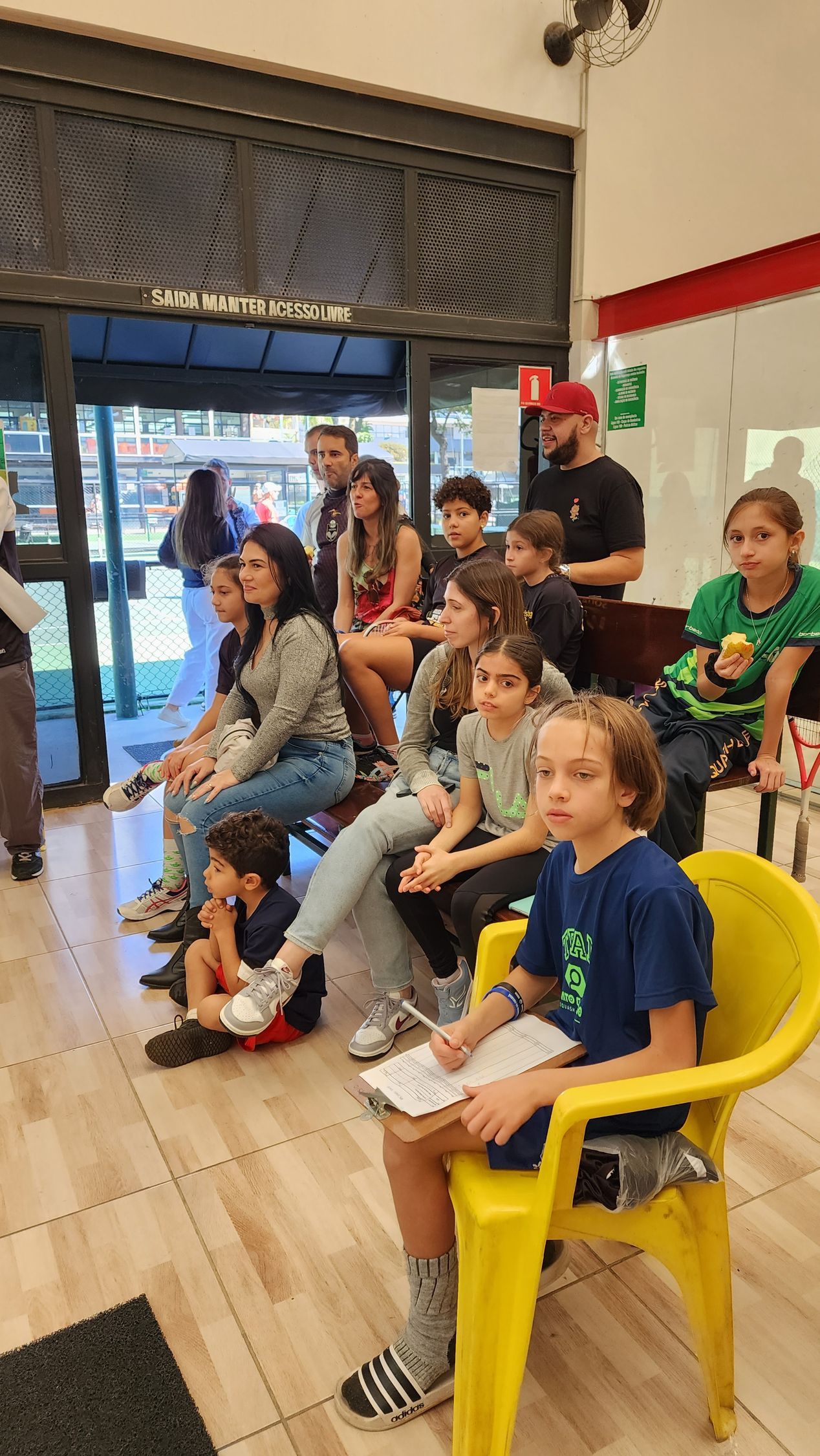 Um grupo de pessoas está sentado em cadeiras em uma sala.