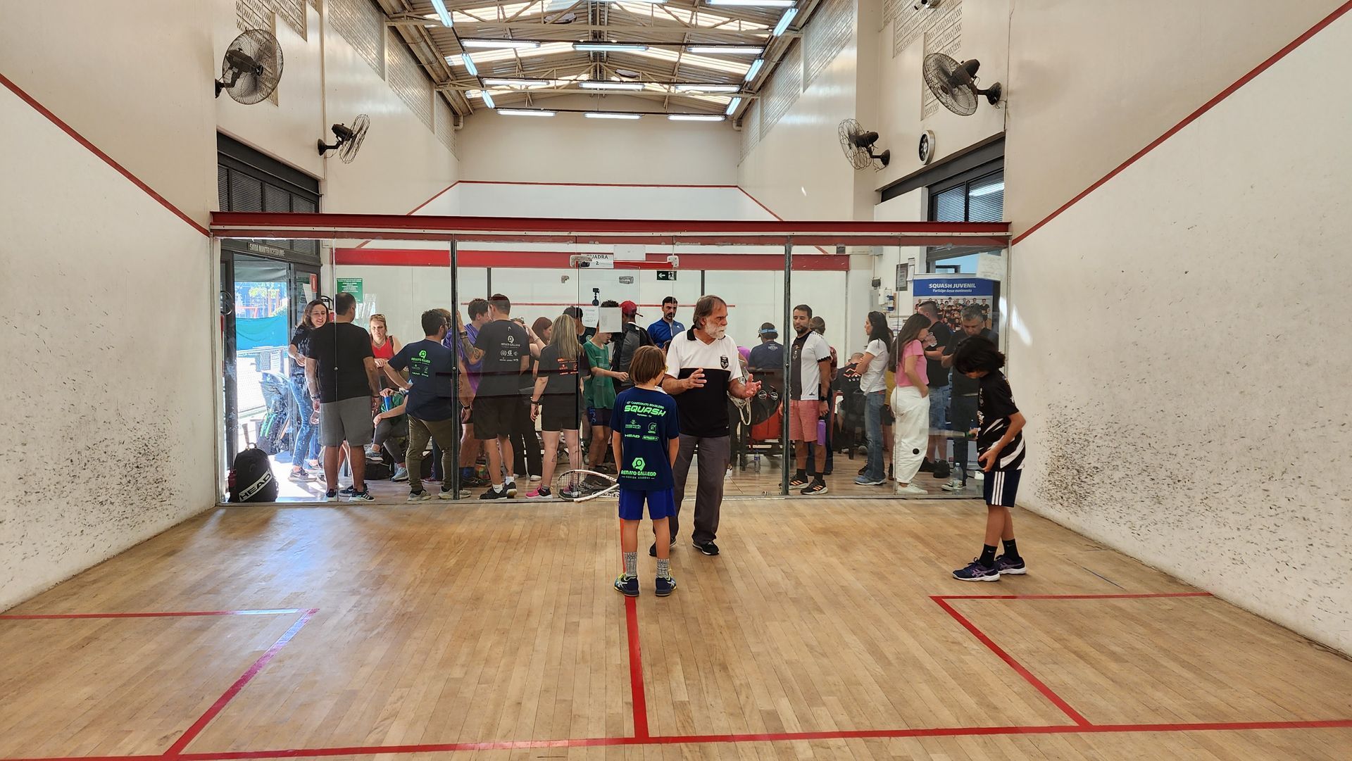 Um grupo de pessoas está jogando squash em uma academia.