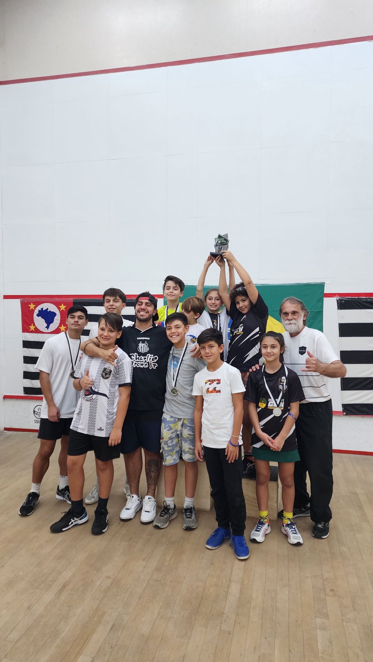 Um grupo de jovens está posando para uma foto em uma academia.