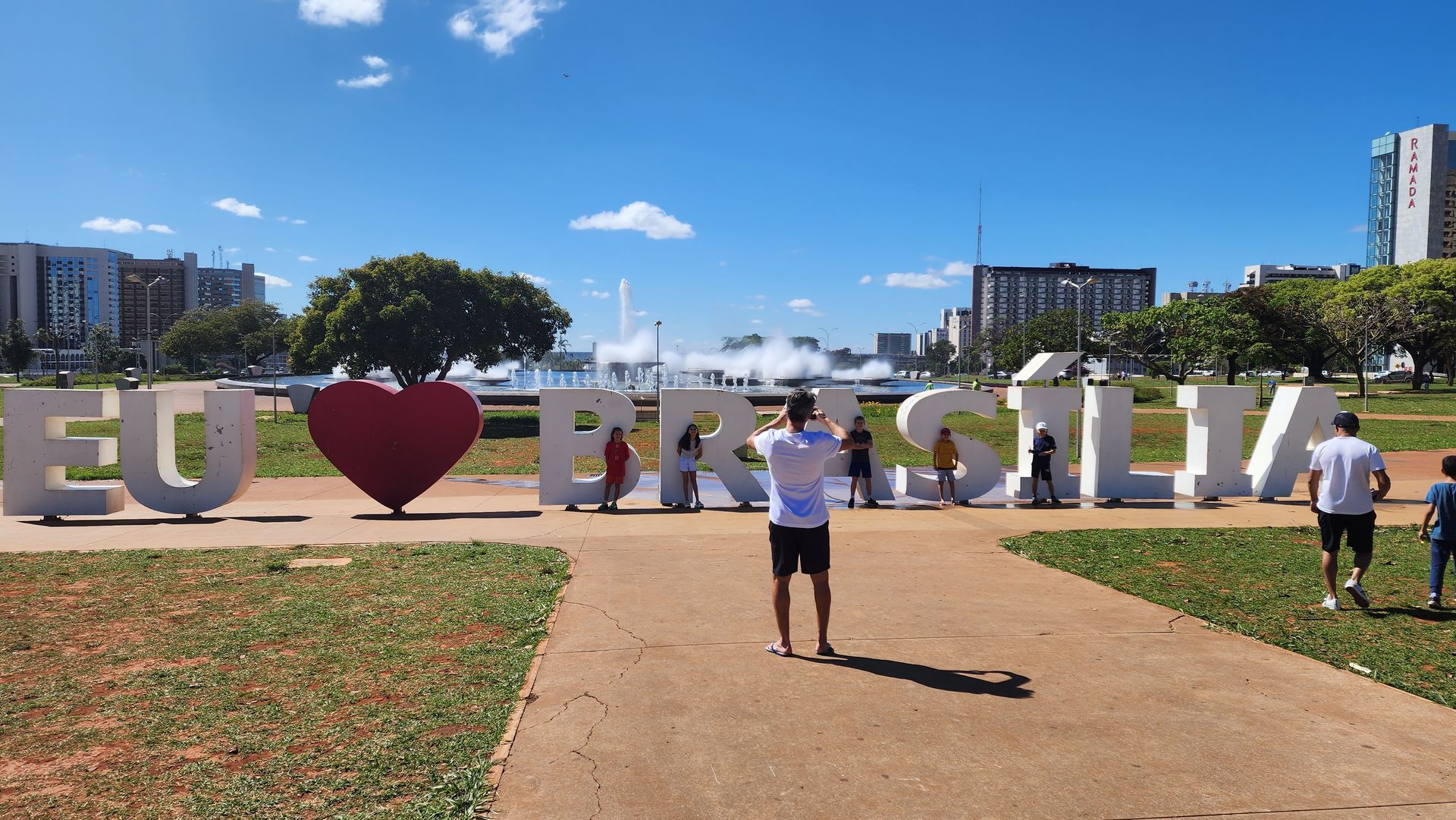Um homem está em frente a uma placa que diz eu amo brasilia