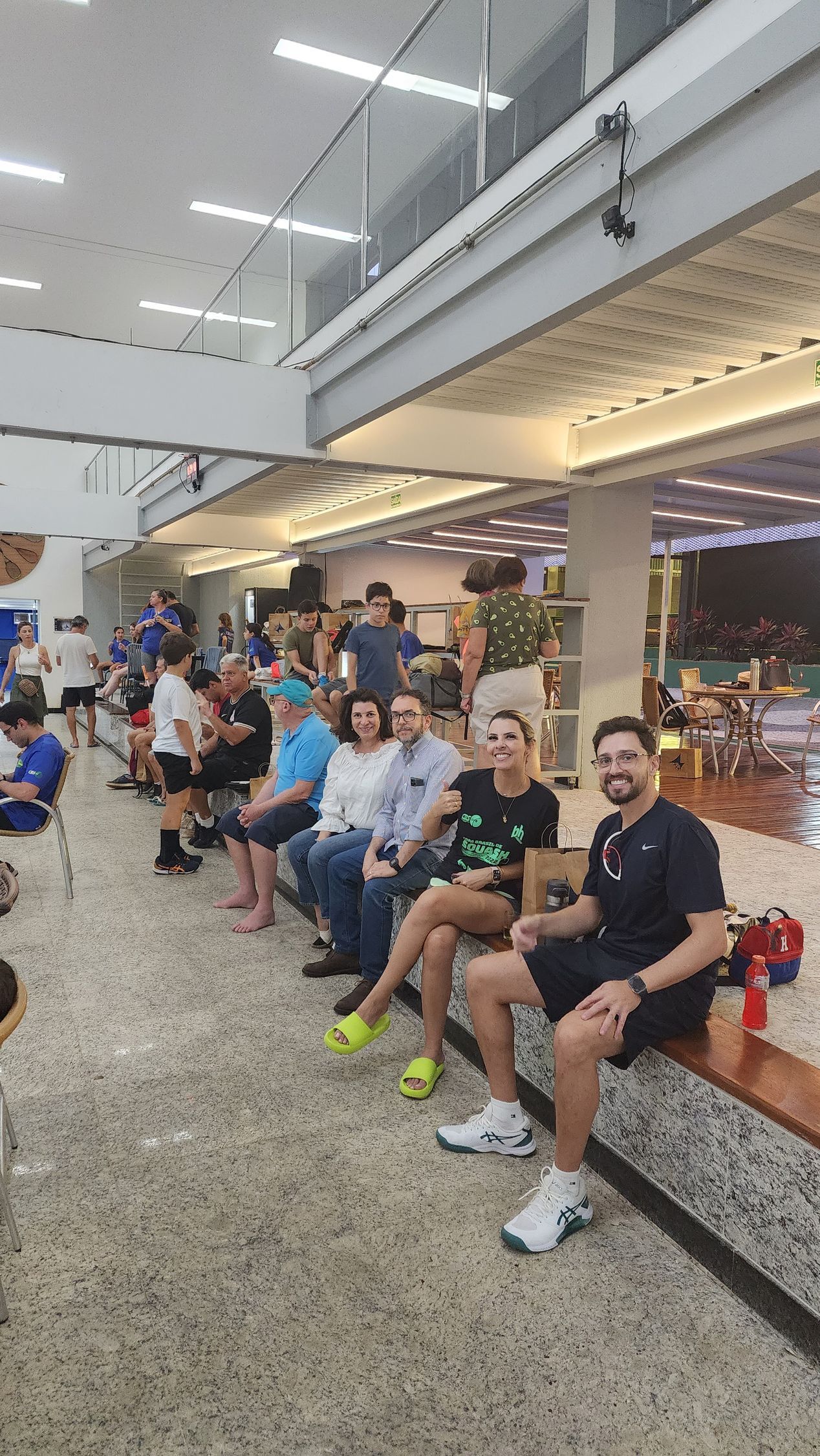 Um grupo de pessoas está sentado em um banco em uma academia.