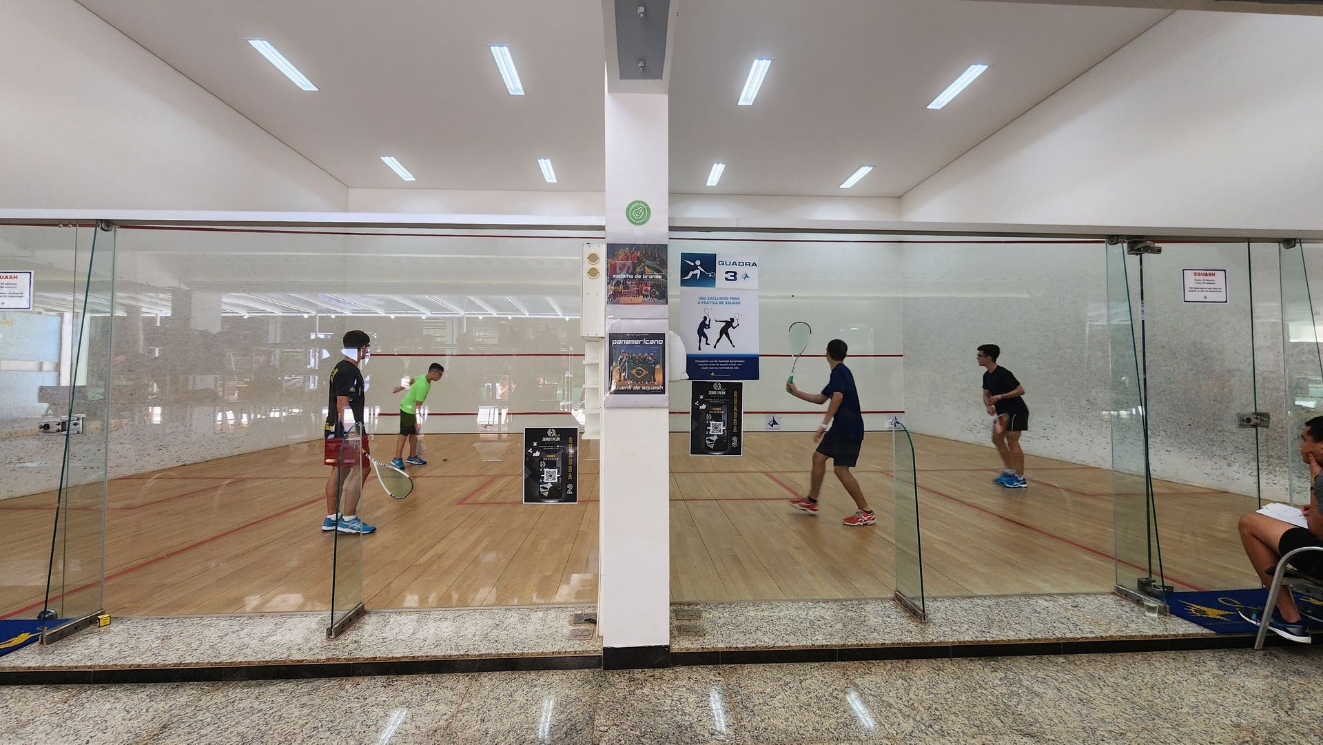 Um grupo de pessoas está jogando squash em uma academia.
