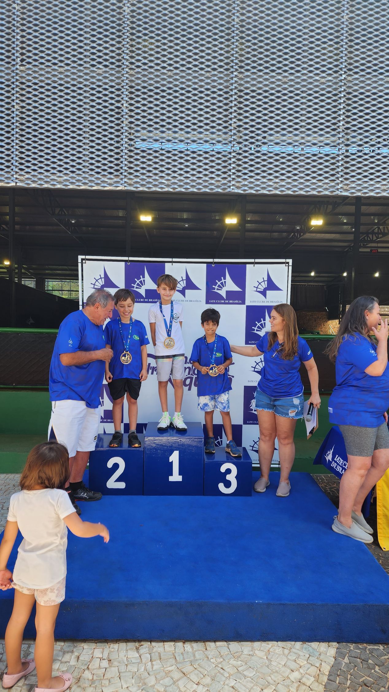 Um grupo de pessoas em pé em um pódio com o número 213 nele