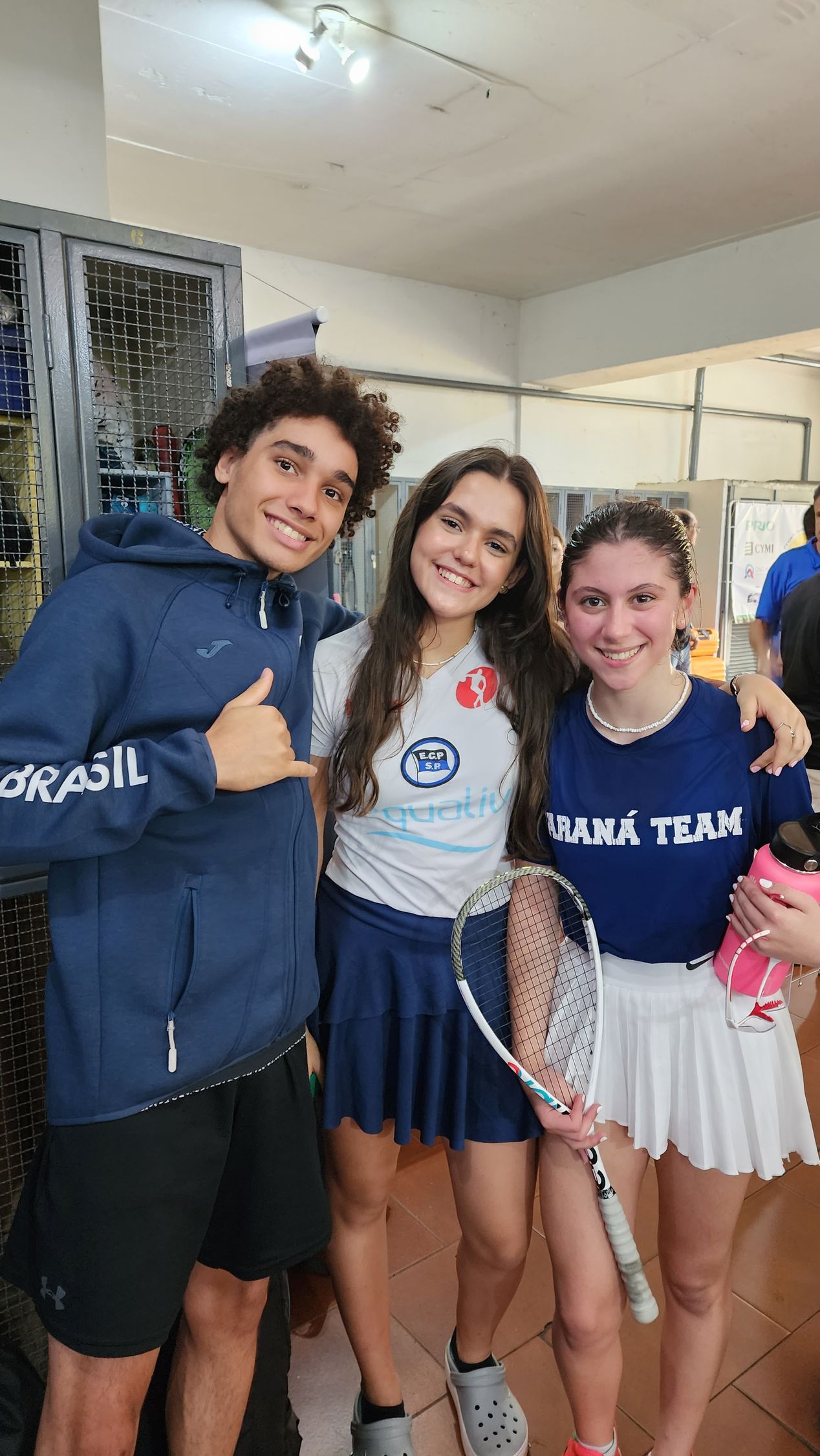 Um grupo de jovens está posando para uma foto em uma sala.