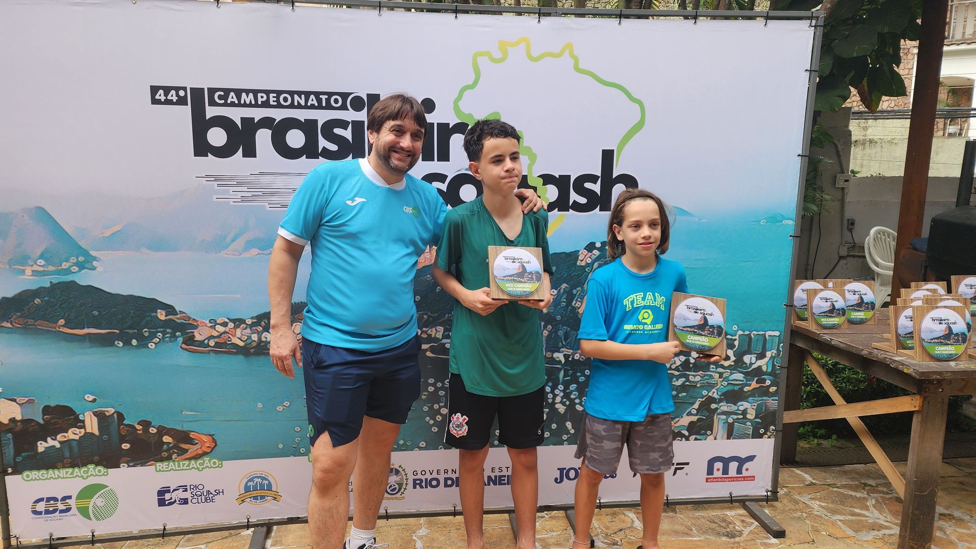 Um grupo de pessoas em pé na frente de uma placa que diz brasil