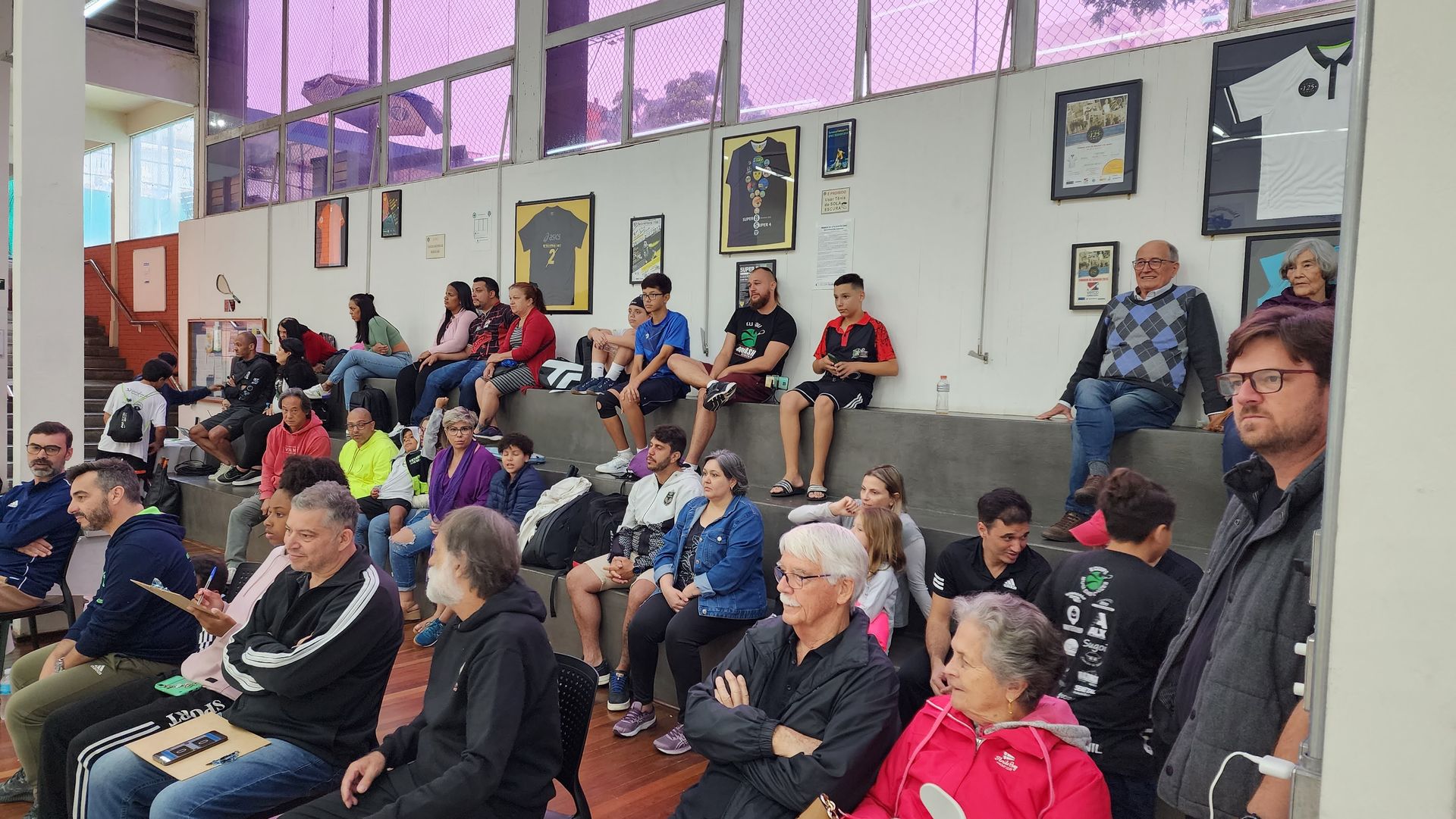 Um grupo de pessoas está sentado em uma sala assistindo a uma apresentação.