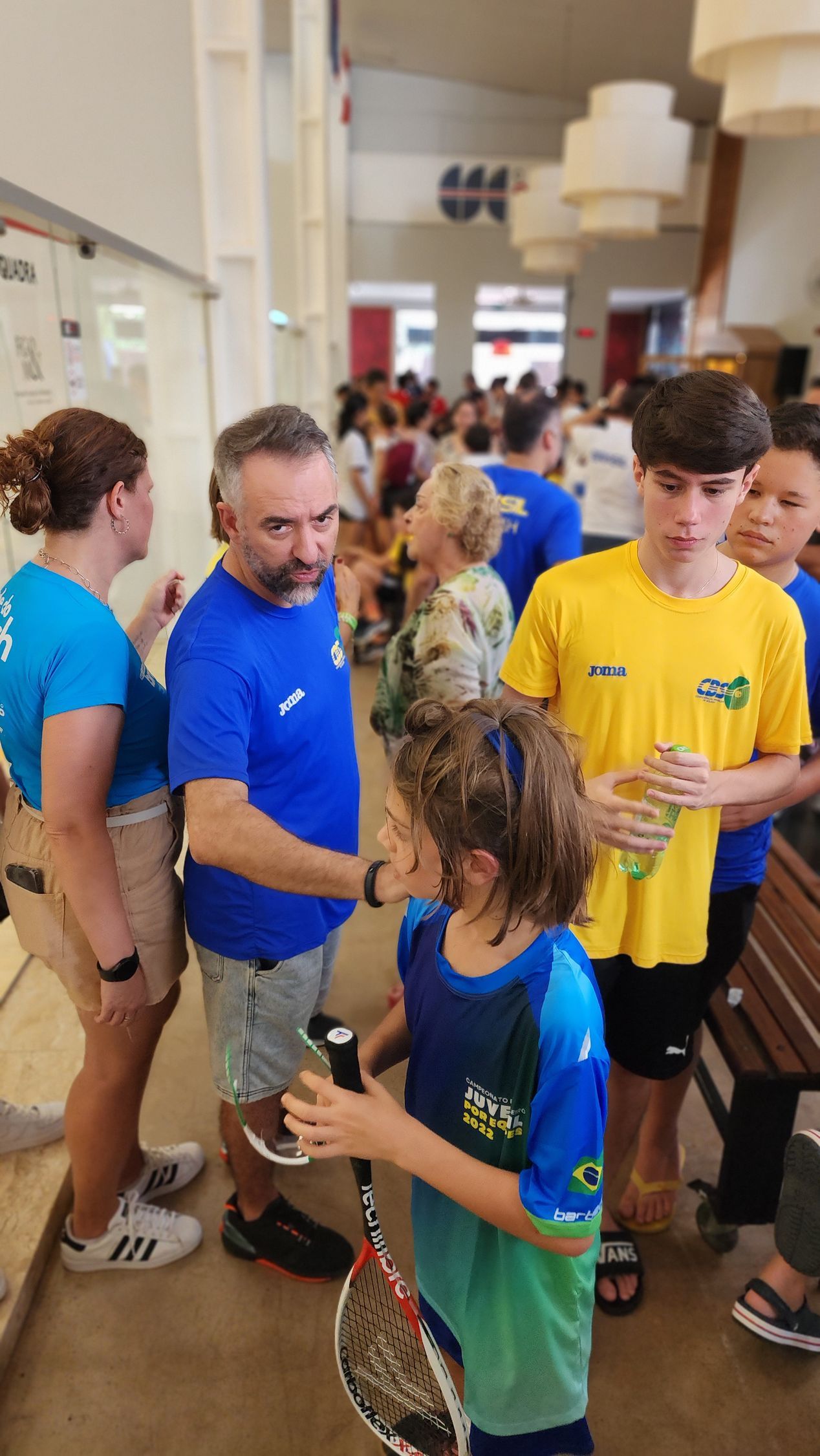 um grupo de pessoas está em uma sala conversando entre si.