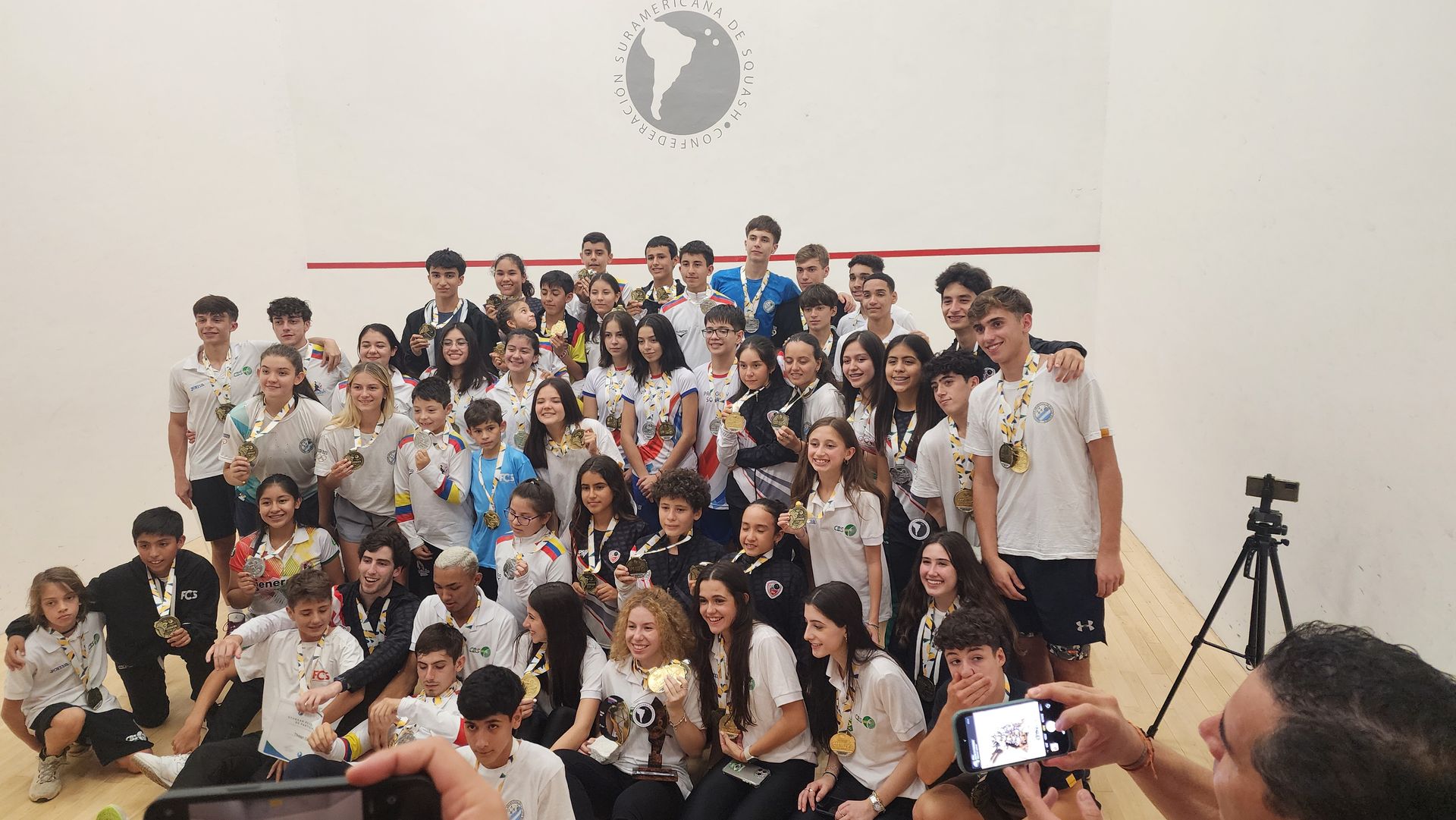 um grupo de pessoas posa para uma foto em uma academia.