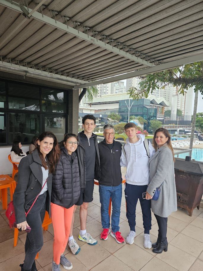 Um grupo de pessoas está posando para uma foto em frente a um prédio.