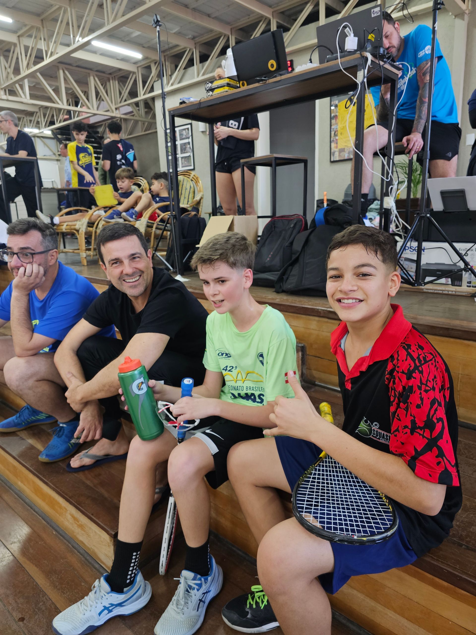 Um grupo de pessoas está sentado em um palco em uma sala.