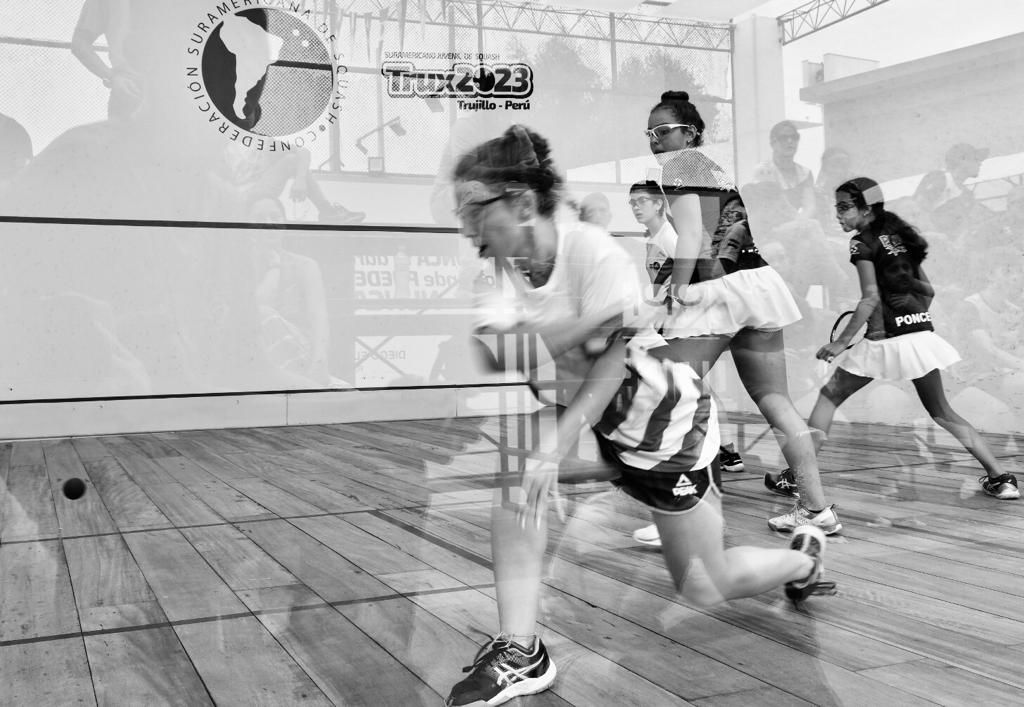 Uma foto em preto e branco de um grupo de mulheres jogando squash