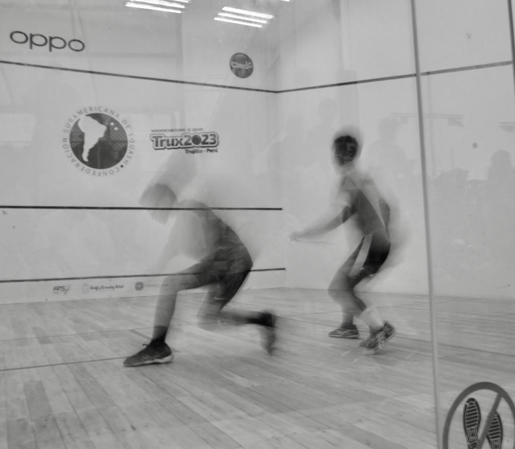 Uma foto em preto e branco de dois homens jogando squash