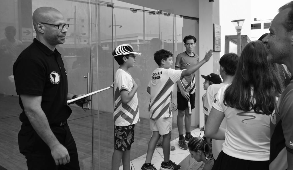 Um homem está parado na frente de um grupo de crianças.