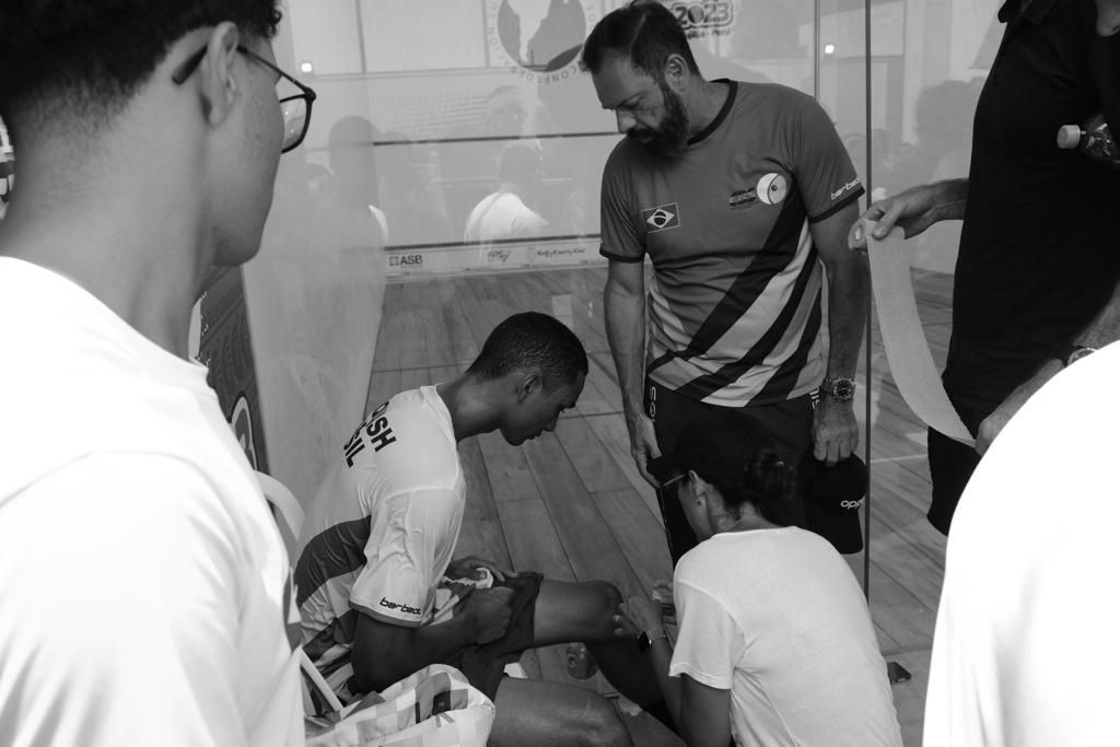 um grupo de homens está em volta de um homem sentado no chão.