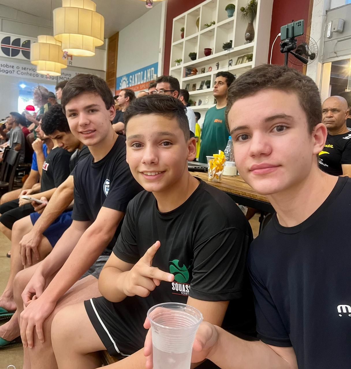 Um grupo de jovens está sentado em uma sala com uma placa que diz