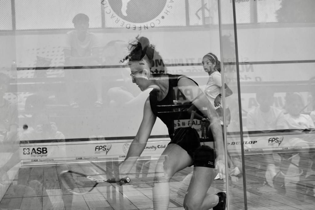 Uma mulher está jogando squash em uma foto em preto e branco.