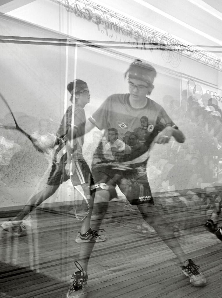 Um homem está jogando squash em uma foto em preto e branco.