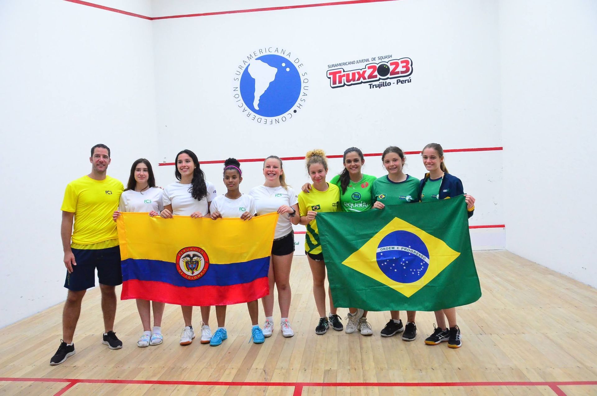 um grupo de pessoas segurando bandeiras em uma quadra de squash
