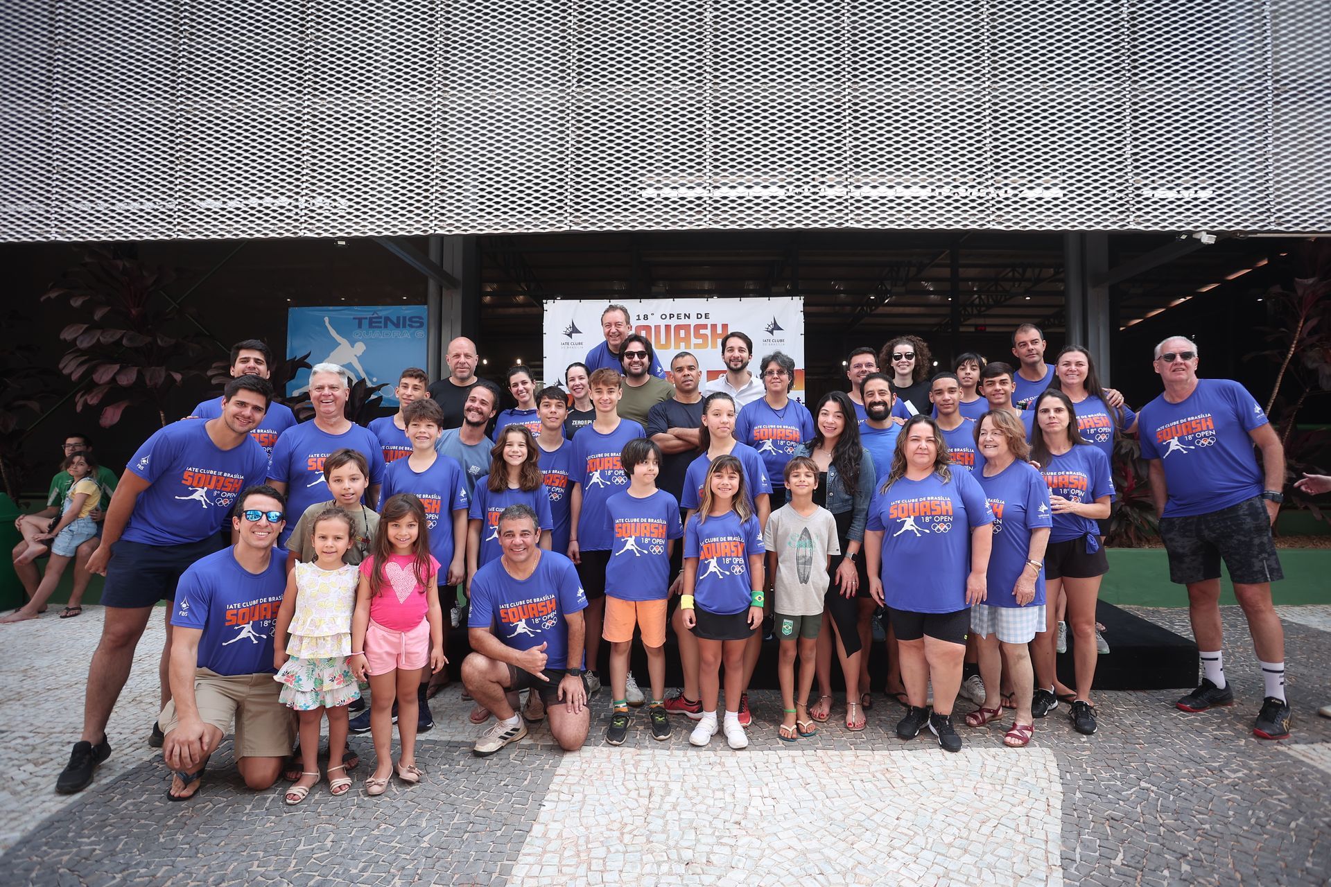 Um grande grupo de pessoas está posando para uma foto em frente a um prédio.