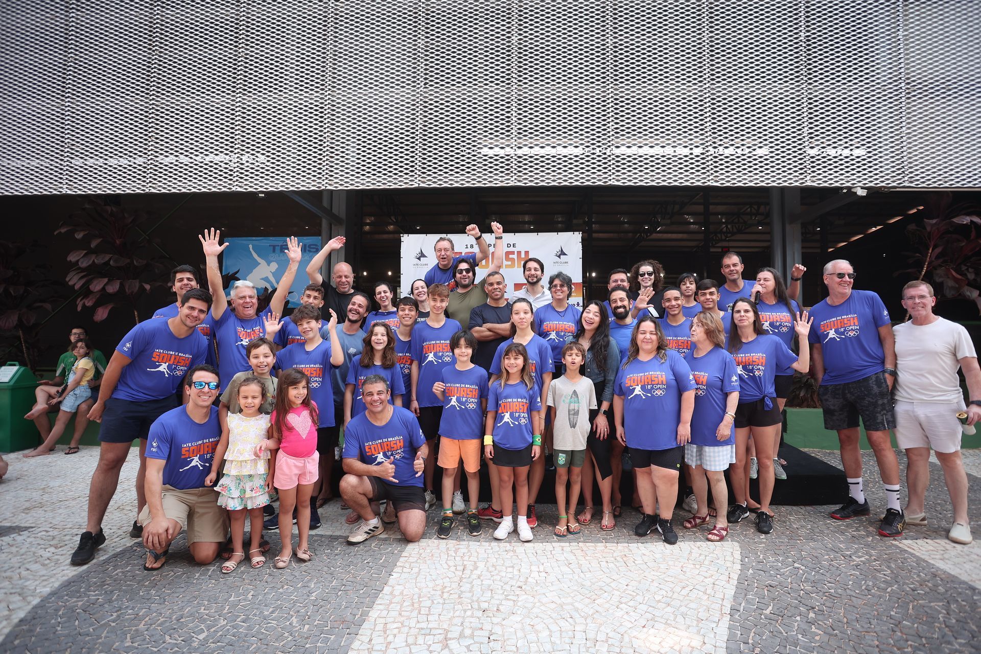 Um grande grupo de pessoas está posando para uma foto em frente a um prédio.