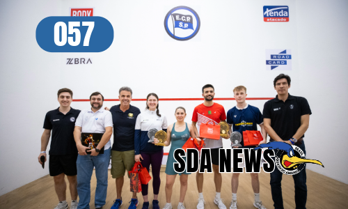 A group of people standing in front of a wall with the number 057 on it.