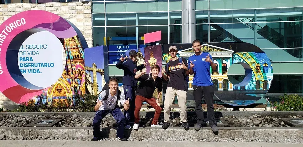 Um grupo de pessoas está posando para uma foto em frente a um prédio.