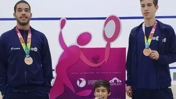 Dois homens e um menino estão posando para uma foto com medalhas penduradas no pescoço.