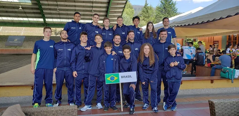 Um grupo de pessoas está posando para uma foto com uma bandeira.