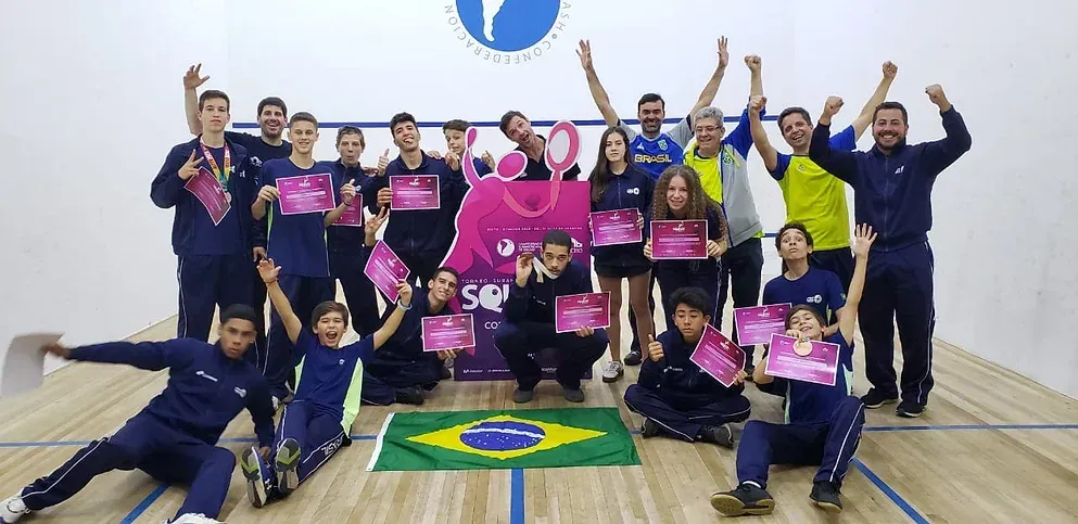 Um grupo de pessoas está posando para uma foto em uma quadra de basquete.