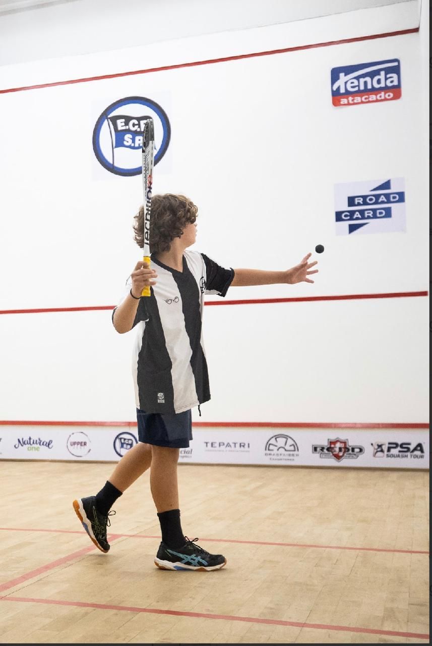 Um homem vestindo uma camisa azul e amarela está sorrindo para a câmera