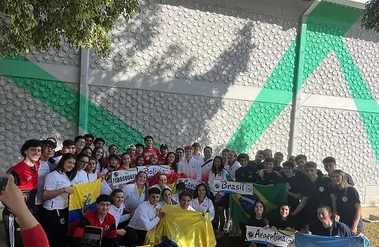 Um grupo de pessoas em pé em frente a um prédio segurando bandeiras.