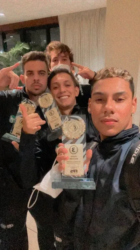 Um grupo de jovens posando para uma foto segurando troféus.