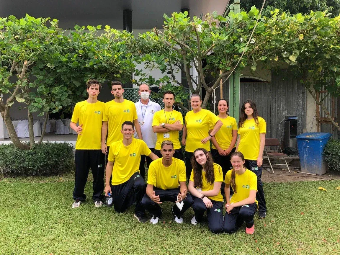 Um grupo de pessoas vestindo camisas amarelas estão posando para uma foto.