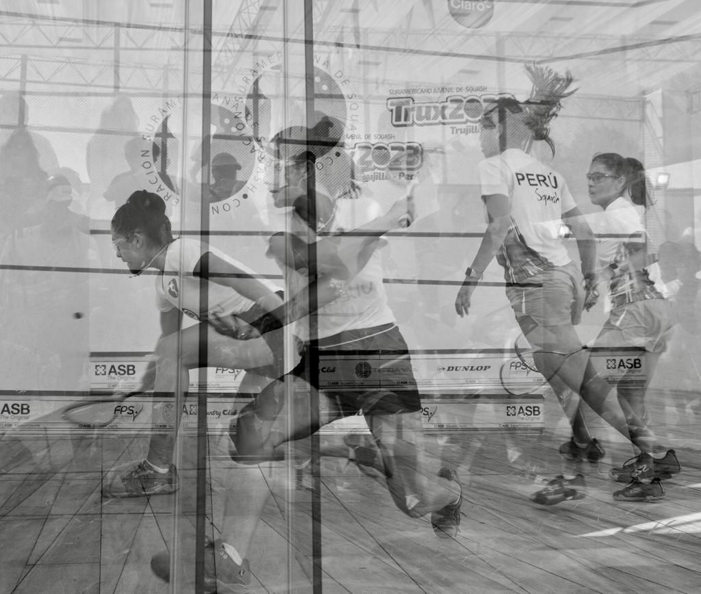 Um grupo de pessoas está jogando squash em uma quadra.