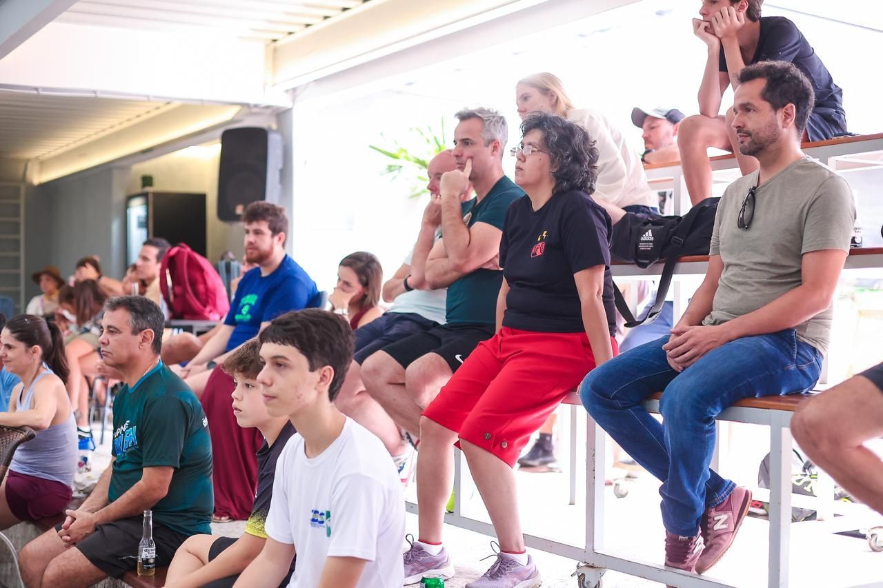 Um grupo de pessoas está sentado em um bar assistindo a um jogo.